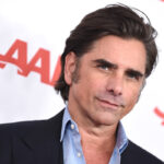 John Stamos se torna cabeças com um novo visual dramático para performances de palco