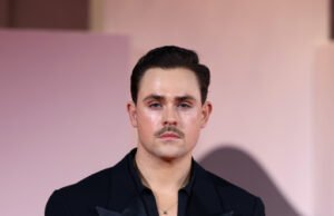 O jogador de ‘Stranger Itens’ limpa em uma roupa monocromática escura para o novo Moody