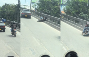 Um motociclista furioso em Bogotá tentou chutar um carro em movimento e acabou no chão