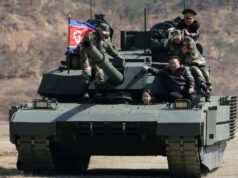 A filha adolescente do líder norte-coreano Kim dirige um veículo blindado enquanto assiste a um exercício militar com seu pai