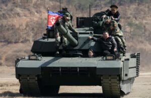 A filha adolescente do líder norte-coreano Kim dirige um veículo blindado enquanto assiste a um exercício militar com seu pai