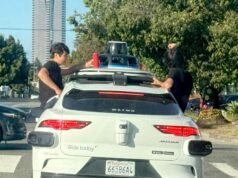 Adolescentes sentam-se perto da janela enquanto Waymo passa no Westside